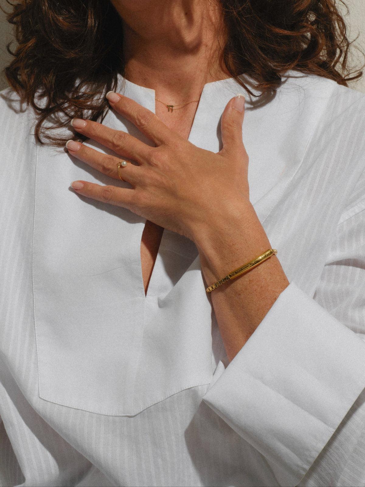 Shema Bracelet Women worn — gold-plated Shema Yisrael bracelet on the wrist, hand on heart — Oriya Jewels