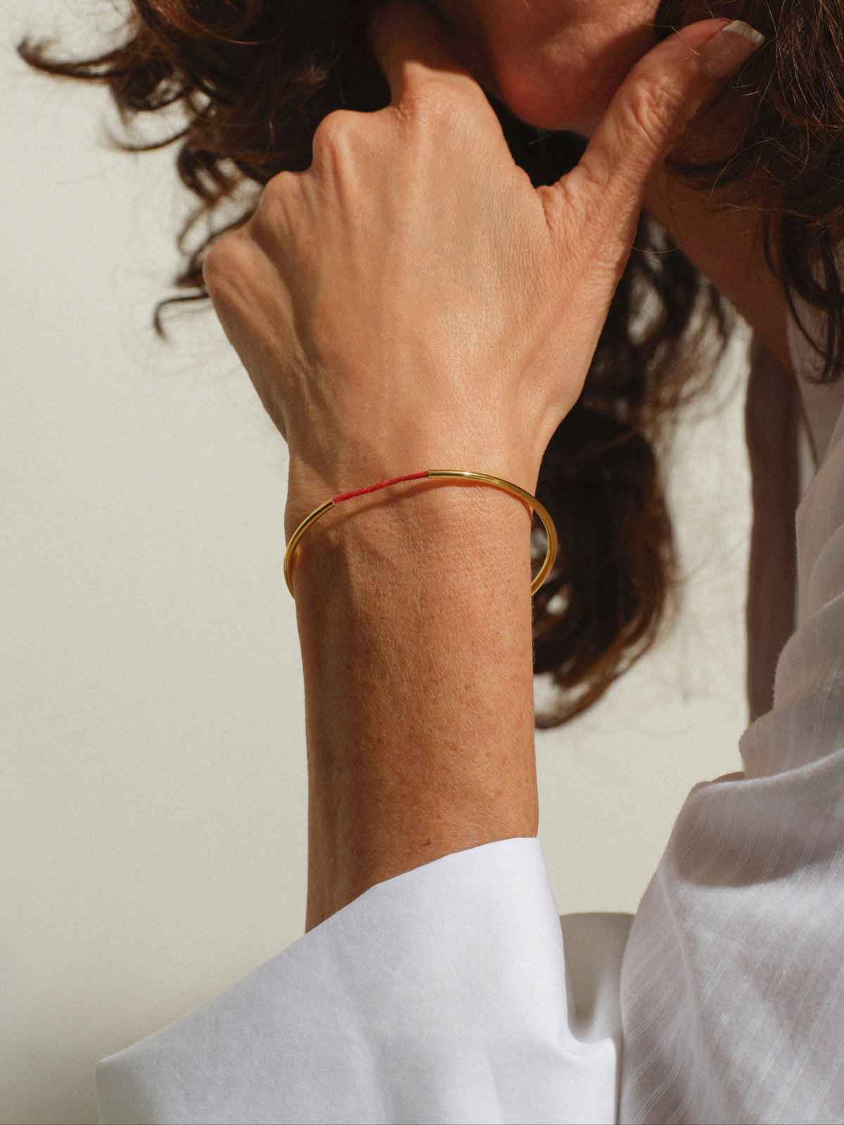Tiferet Bangle worn — 18k gold-plated bangle with the original Kabbalah red thread on the wrist — Oriya Jewels